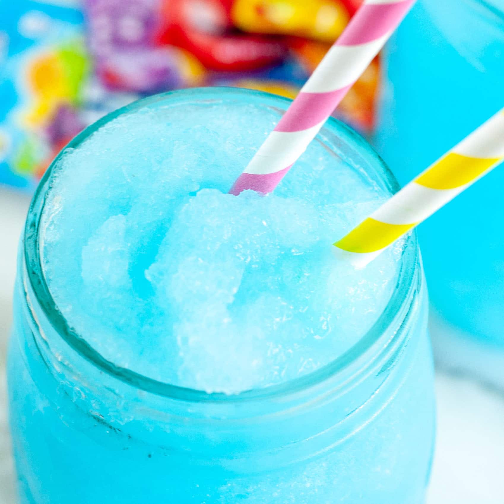 A blue slushie drink with a purple and yellow swirly straw.