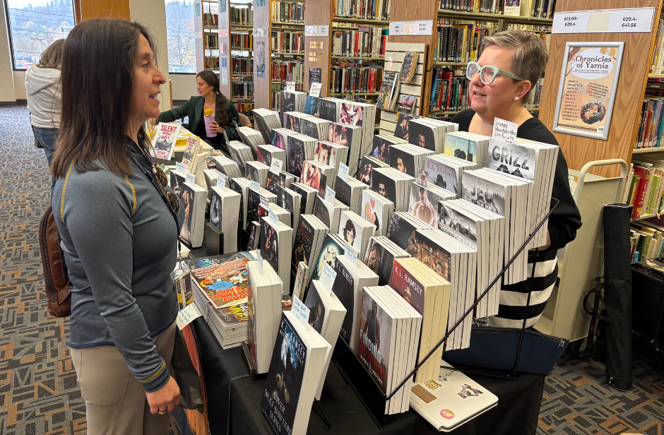 Author KL Ramsey talks to a customer behind her book display